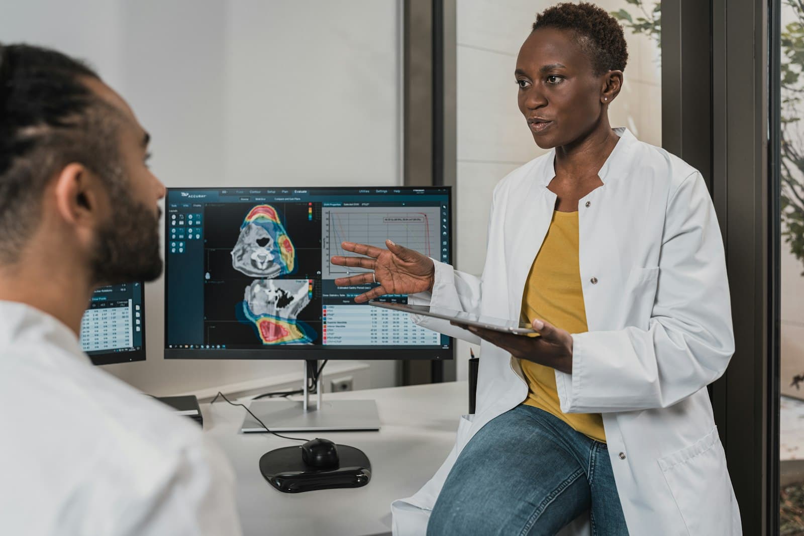 Healthcare providers at a workstation reviewing clinical results on a computer